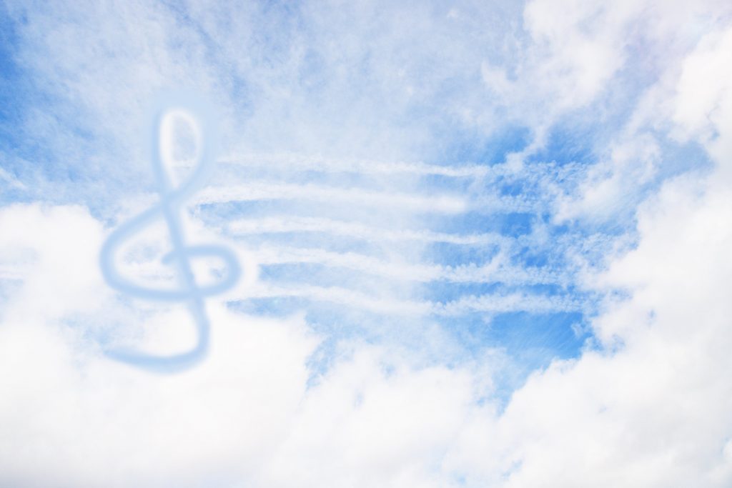 muzyczne niebo, chmura układająca się w kształt klucza wiolinowego na niebieskim niebie
