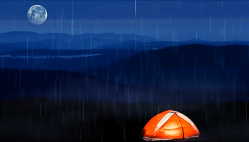 pomarańczowy namiot nocą podczas deszczu w górach
