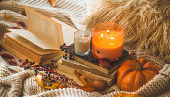 książki, świeczki, sezonowe warzywa, leżą na kocy - jesienny klimat